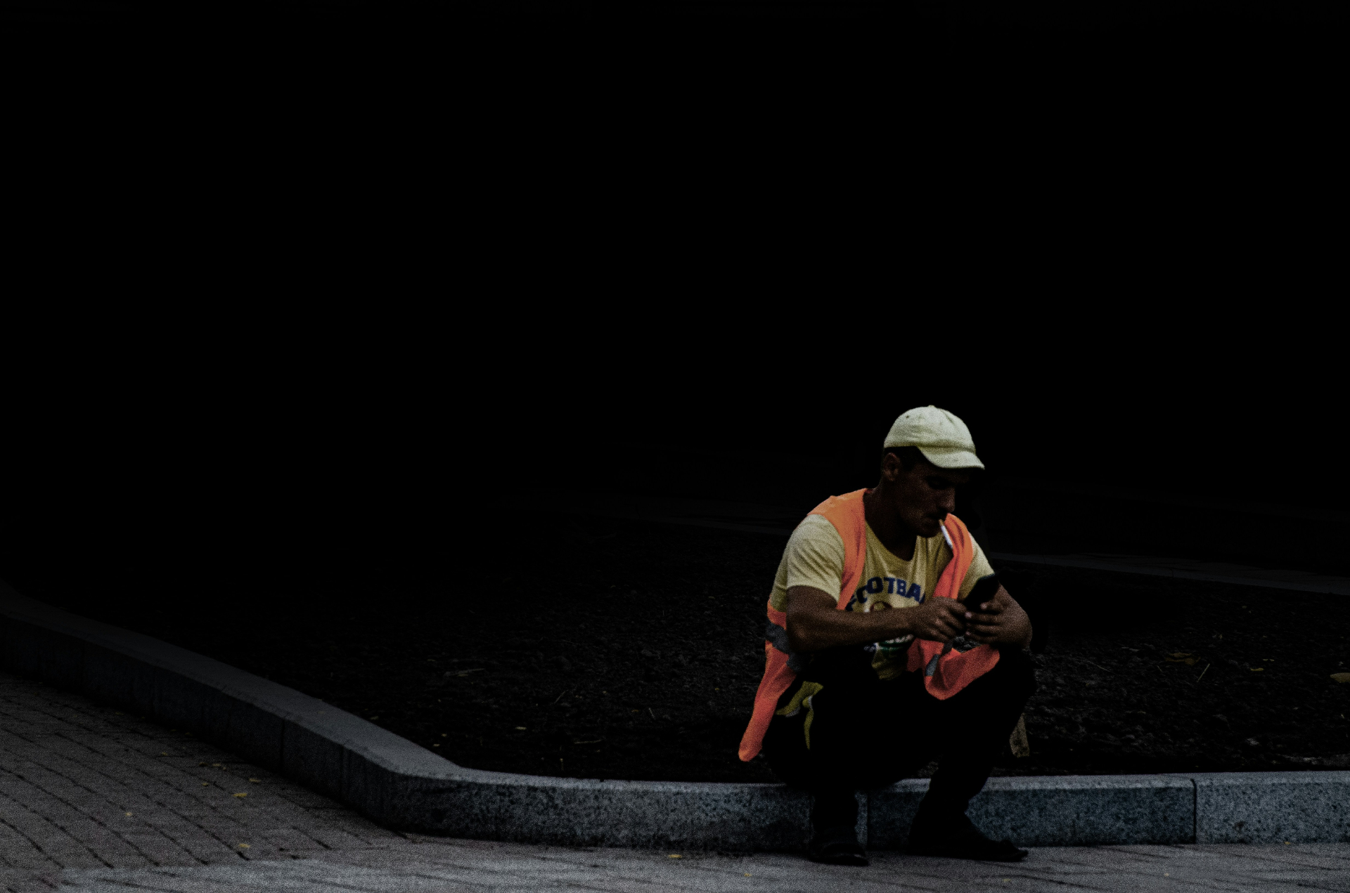 Construction worker checking phone on a jobsite at night