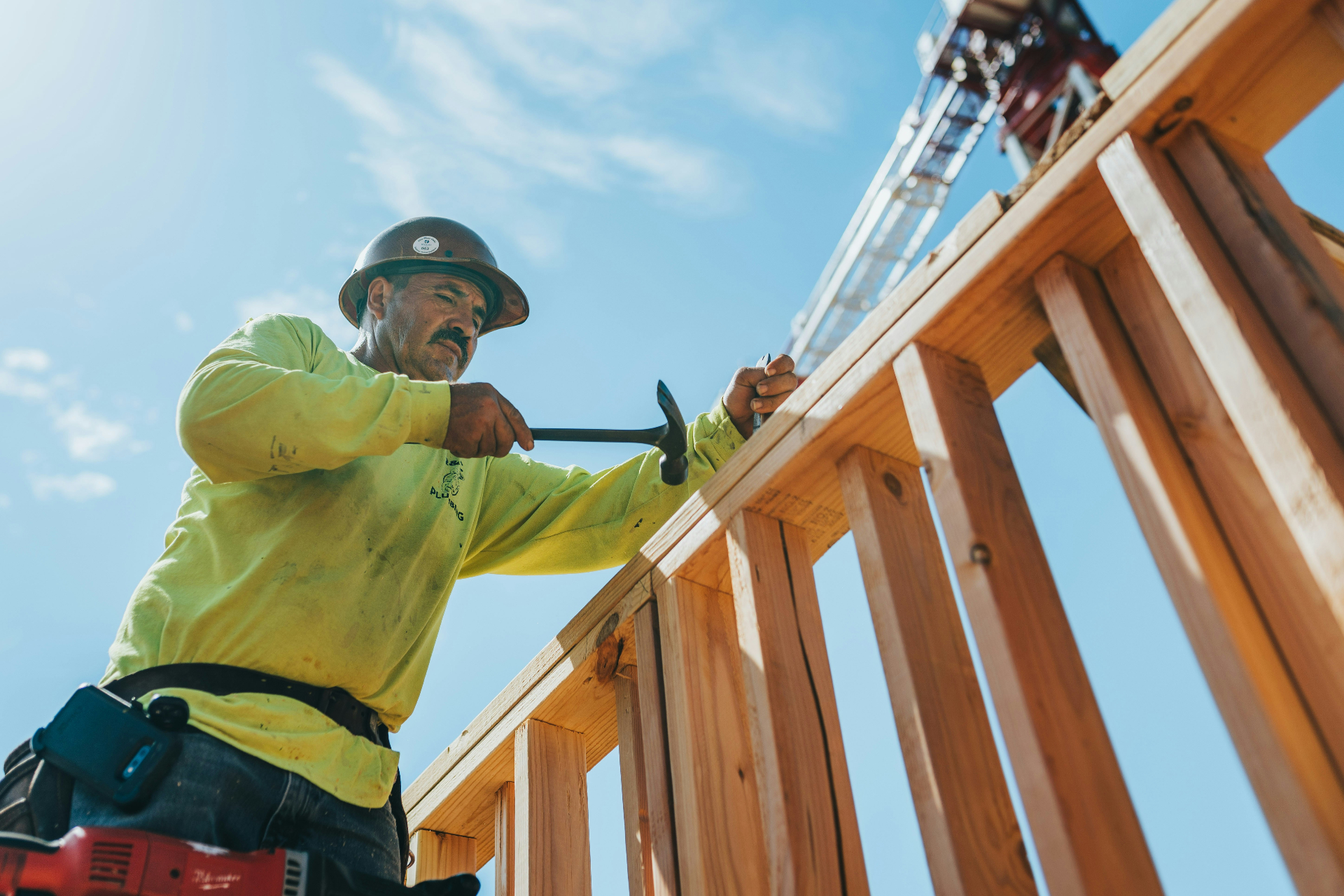 Construction worker hammering wood framing on a build site